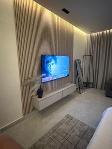 a living room with a flat screen tv on a wall at استيديو فاخر ومميز شمال الرياض حي ملقا b6 in Quai