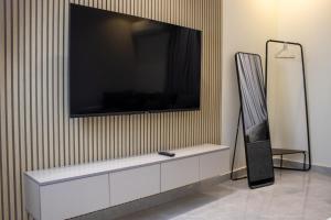 a flat screen tv hanging on a wall at استيديو فاخر ومميز شمال الرياض حي ملقا b6 in Quai