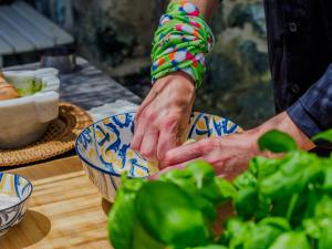 a person preparing food in a bowl on a table at La Pavona Villa Luxury Collection in Monterosso al Mare