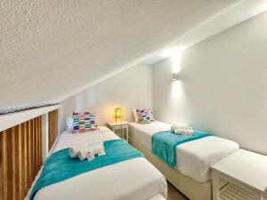 two beds in a room with white walls at Vilamoura Marina View 4 by Homing in Vilamoura
