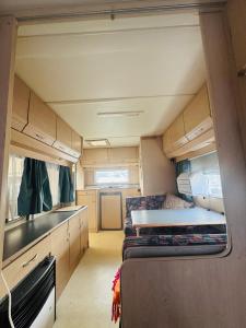an interior view of an rv with a bed and a kitchen at Przyczepa Campingowa Loop it 30m od Zatoki Puckiej, Jastarnia in Jastarnia