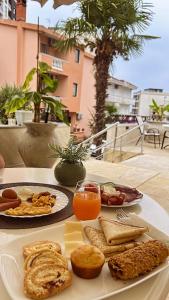a table with a plate of bread and orange juice at Donna in Ulcinj