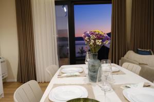 een tafel met borden en een vaas met bloemen erop bij Casa Magnolia in Vlorë