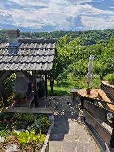 a garden with a wooden table and a bench at GREENHILLS Relax & Holiday House in Kebel +57 photos