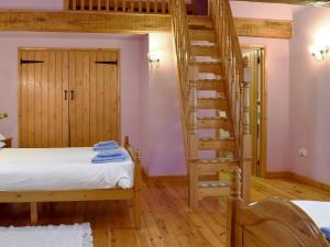 a room with a bed and a spiral staircase at The Barn - B6206A in Onecote