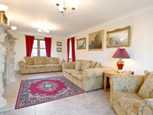 a living room with couches and a table at Magnolia Cottage in Aberaeron