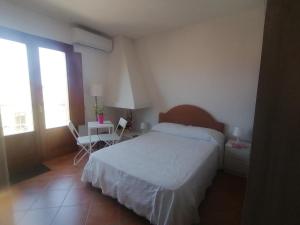 a bedroom with a bed and a table and a window at Relix in Càbras +4 photos