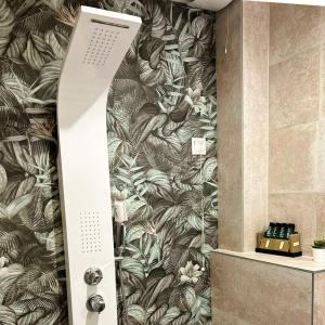a bathroom with a shower with a tropical wallpaper at City Gate Hotel Airport Thessaloniki in Thessaloniki