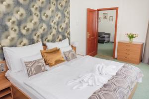 a large white bed with two white towels on it at Hotel Anna Villa in Balatonföldvár +37 photos