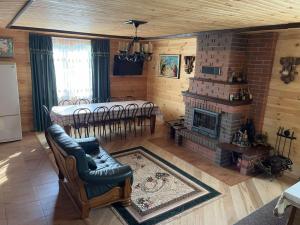 a living room with a fireplace and a table and chairs at Дача Тиха in Dubyna