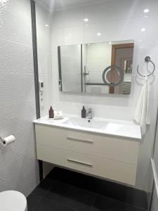 a white bathroom with a sink and a mirror at Penthouse & Jacuzzi With Sea Views In Costa Blanca in Orihuela Costa