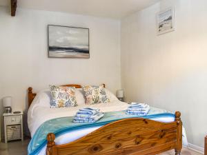a bedroom with a bed with towels on it at Tarow Cottage in East Looe +7 photos