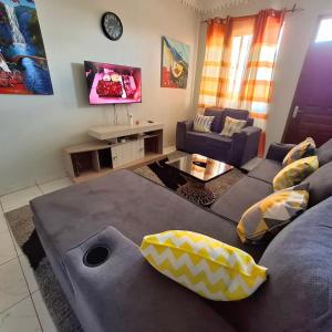a living room with a couch and a tv at HawiHomes in Mombasa +6 photos