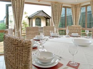 a table with white plates and glasses on it at Magnolia Cottage in Aberaeron