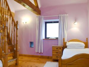a bedroom with purple walls and a bed and a window at The Barn - B6206A in Onecote +6 photos