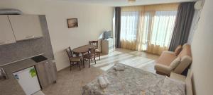 a living room with a couch and a table in a room at Sunny Sands Studios in Burgas