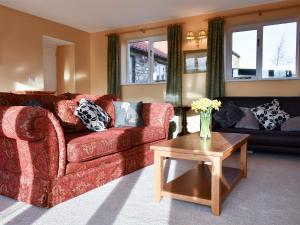 a living room with a red couch and a table at Grange Cottage in Winston
