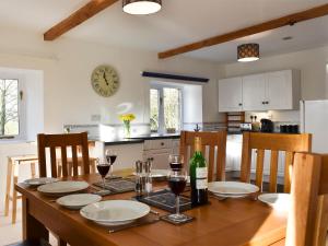 a kitchen and dining room with a table with glasses of wine at Grange Cottage in Winston +12 photos
