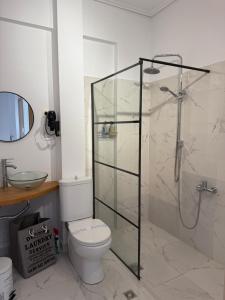 ein Badezimmer mit Toilette und Glasdusche in der Unterkunft Cleo in Spáta