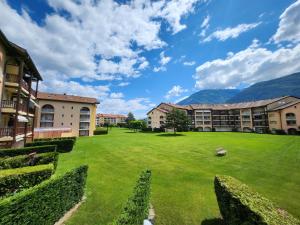 a large grassy yard in front of buildings at Studio lumineux et calme - Séjour bien-être aux Bains de Saillon in Saillon