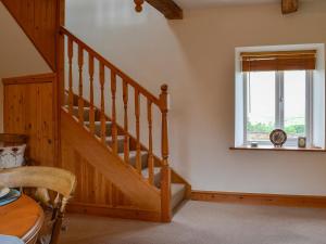 eine Treppe in einem Zimmer mit einem Tisch und einem Fenster in der Unterkunft Farm Cottage in Cleator
