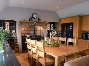 a kitchen with a wooden dining room table with chairs at The Old Farmhouse in Ancroft +29 photos