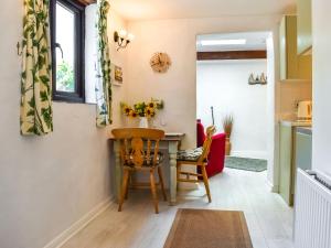a kitchen and dining room with a table and chairs at Tarow Cottage in East Looe
