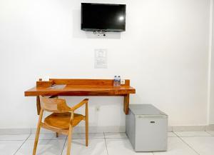 a desk with a chair and a television on a wall at Balian Paradise Hotel in Selemadeg