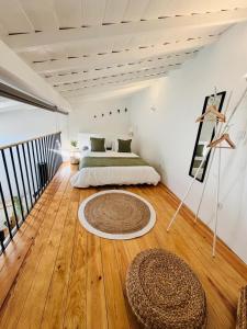 a bedroom with a bed and a rug on a wooden floor at Casa das Andorinhas-Alentejo in Vidigueira