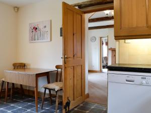 eine Küche mit einer Tür, die sich zu einer Küche mit einem Tisch öffnet in der Unterkunft Farm Cottage in Cleator + 20 Fotos
