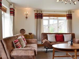 ein Wohnzimmer mit zwei Sofas und einem Tisch in der Unterkunft Farm Cottage in Cleator