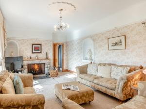 a living room with a couch and a fireplace at The Old Farmhouse in Ancroft