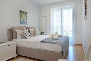 a white bedroom with a large bed and a window at New Luxury Dorcol Downtown Apartment in Belgrade +33 photos