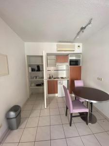 a small kitchen with a table and chairs in a room at Studio Cité médiévale 250 m in Carcassonne