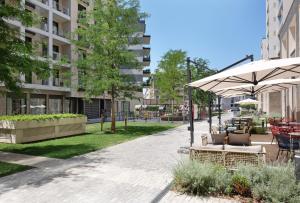 a patio with chairs and an umbrella in a park at New Luxury Dorcol Downtown Apartment in Belgrade