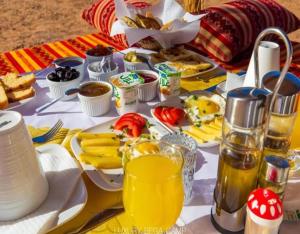 a table with breakfast foods and drinks on it at Erg Serenity Camp in Merzouga