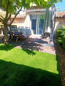 a patio with chairs and a tree in a yard at coeur de village in Velleron