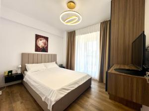 a bedroom with a bed and a flat screen tv at Otopeni KaryKay Airport Residence in Otopeni