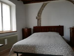 a bedroom with a bed and a tree in the corner at Sot I Volz - Affittacamere in Arta Terme