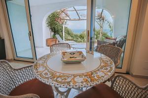 a table and chairs with a bowl on top of it at Villetta La Dolce Vista in Conca dei Marini