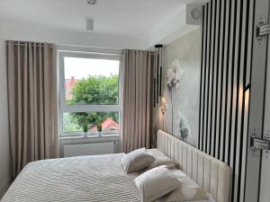 a bedroom with a large bed and a window at Nowy apartament z dwoma sypialniami i garażem in Biskupiec +11 photos