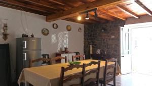 a dining room with a table and a refrigerator at Casa d'Avó in Carrapateira