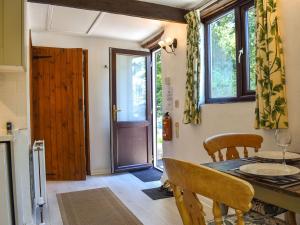 a dining room with a table and chairs and a door at Tarow Cottage in East Looe