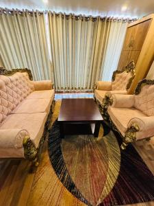 a living room with two couches and a coffee table at Kwality Beach Resort in Beni Ghāt