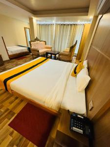 a hotel room with a large bed with a phone on it at Kwality Beach Resort in Beni Ghāt