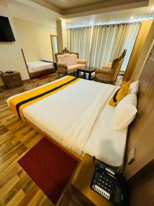 a hotel room with a large bed with a phone on it at Kwality Beach Resort in Beni Ghāt