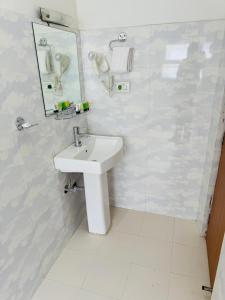a white bathroom with a sink and a mirror at Kwality Beach Resort in Beni Ghāt