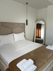 a bedroom with a large bed with two towels on it at Inscape Apartments in Sarandë