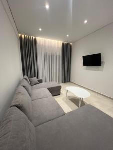 a living room with a couch and a tv at Inscape Apartments in Sarandë