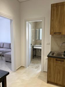 a kitchen with a sink and a living room at Inscape Apartments in Sarandë +42 photos